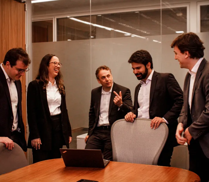 Grupo de executivos rindo e conversando em um ambiente corporativo